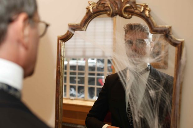 Dr. Konstantin looks into a spiderweb covered mirror