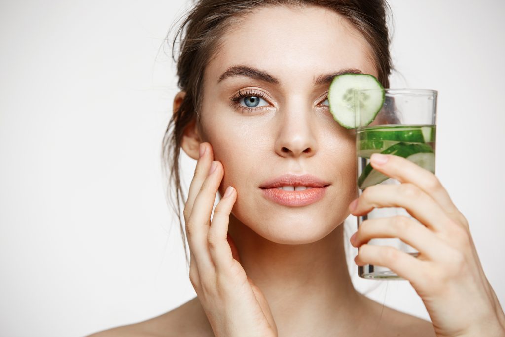 A woman holding a healthy beverage near her face