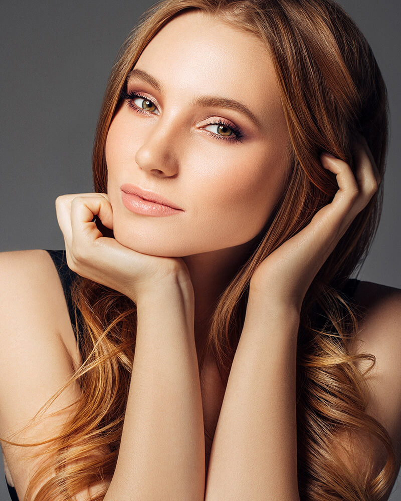 Young woman with her hands on her chin